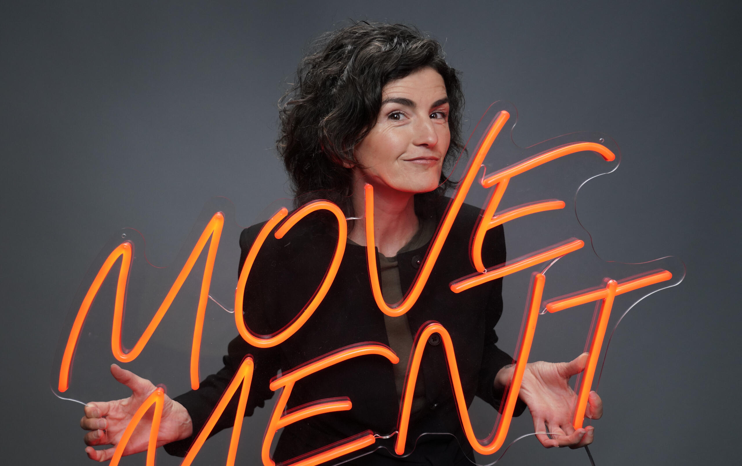 Dolores Stef holding a sign that says "movement"