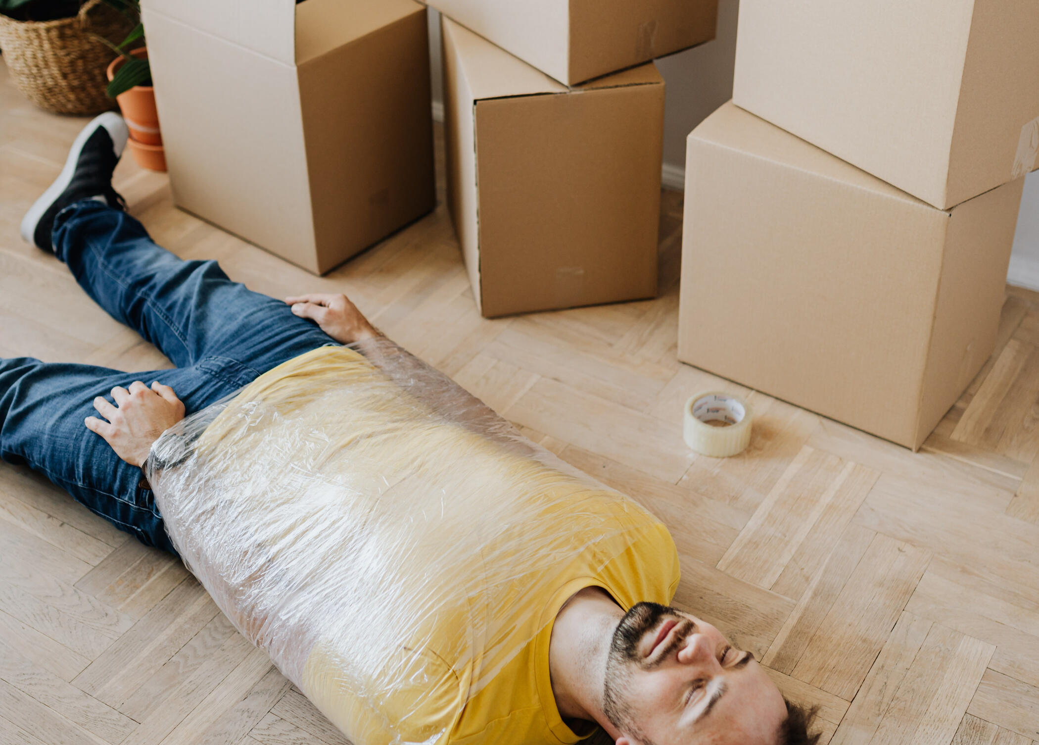 A man wrapped in plastic, packing boxes